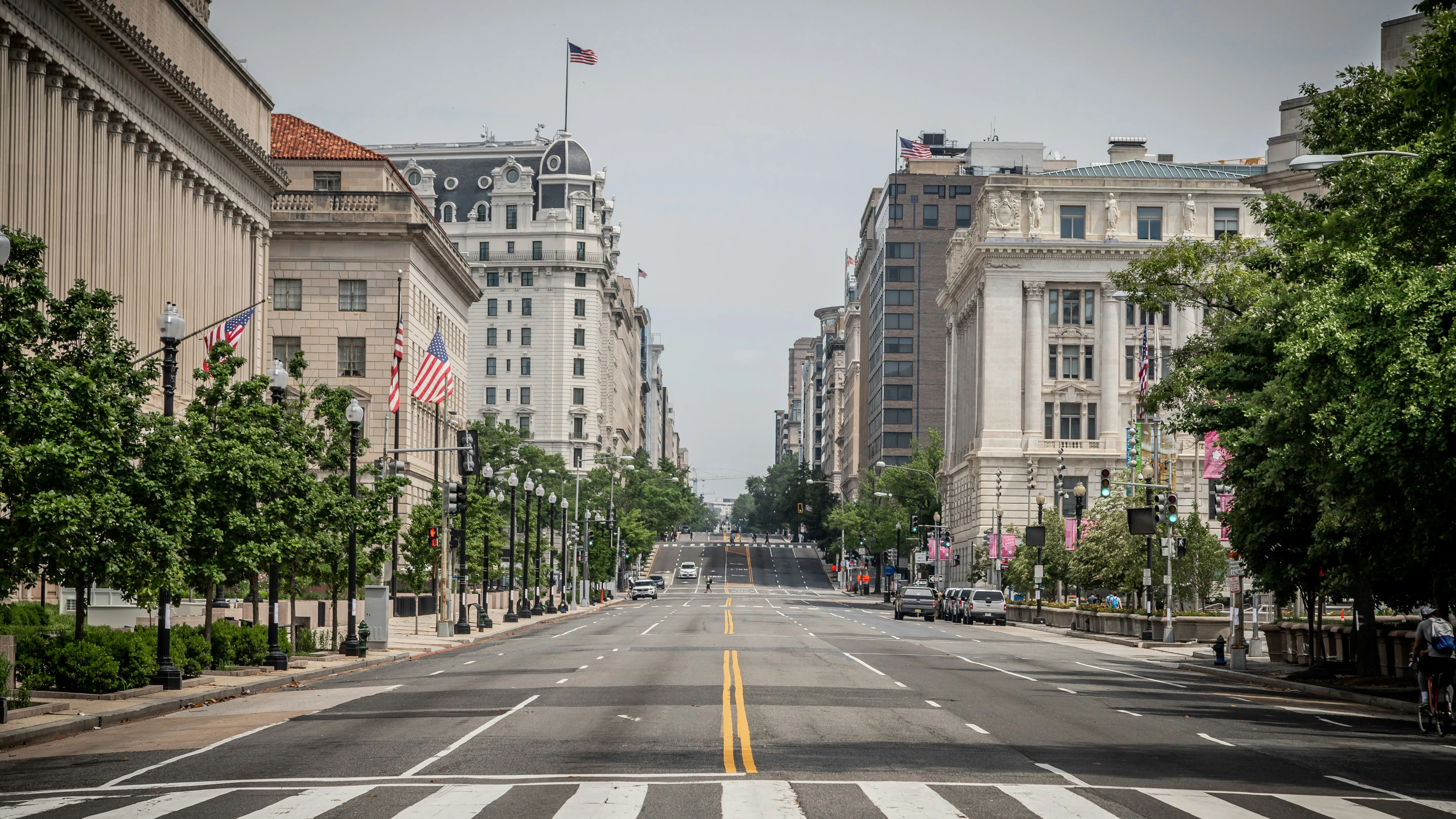 A wide downtown avenue in Washington, D.C., flanked by government office buildings.